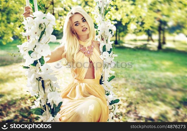 Pretty blond lady swinging on the ornate seesaw