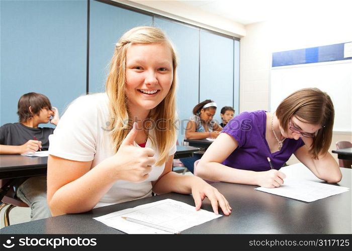 Pretty blond teen gives a thumbs up because she did well on a school test.