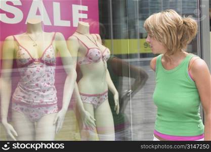 Pretty blond woman checking the window display