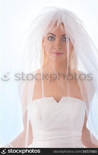 pretty blonde girl dressing as bride with white veil over face, blonde smooth hair looks in camera