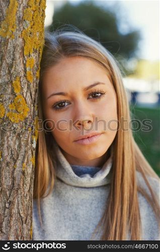 Pretty blonde girl in the park looking at camera