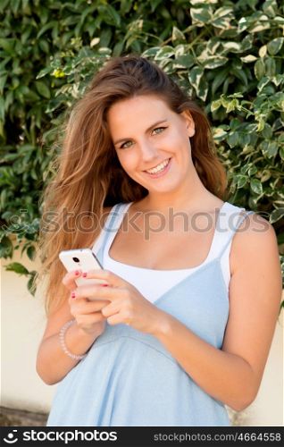 Pretty blonde girl in the park with a mobile