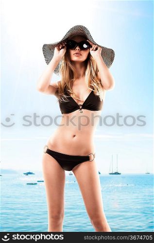 pretty blonde girl posing in bikini summer hat and sunglasses looking up
