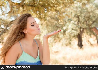 Pretty blonde girl throwing a kiss on a sunny day