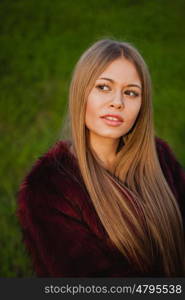 Pretty blonde girl with a beautiful long an grass of background