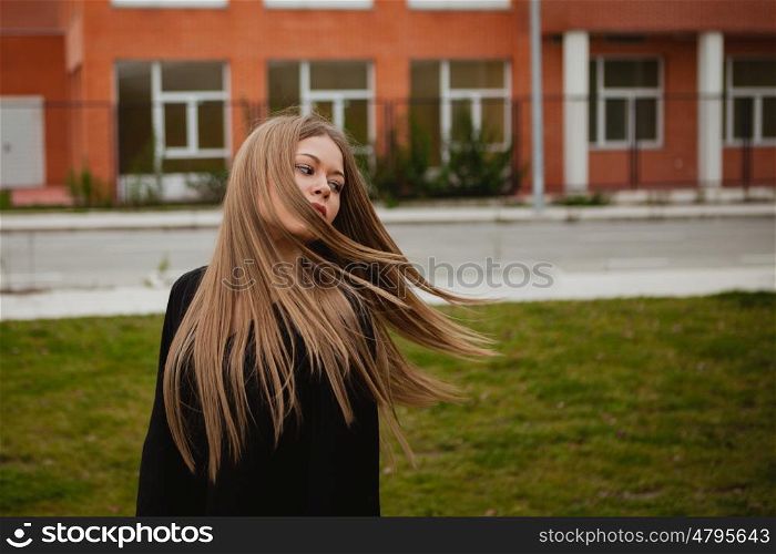 Pretty blonde girl with a beautiful long an grass of background