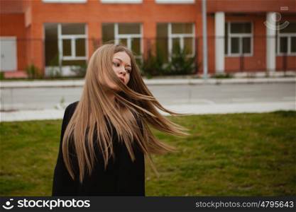 Pretty blonde girl with a beautiful long an grass of background