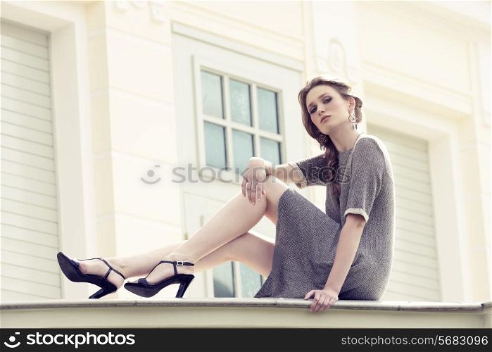 pretty blonde girl with braid hair-style and elegant dress posing in fashion outdoor portrait, wearing pretty jewellery