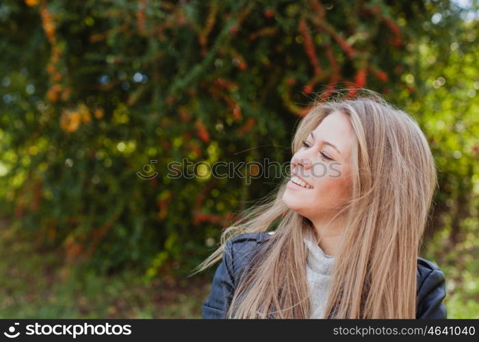 Pretty blonde girl with leather jacket in the street in a autumn day