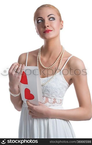pretty blonde girl with white dress, pearl necklace and valentine postcard in the hands