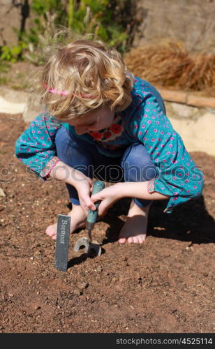 Pretty blonde haired girl gardening on a sunny day