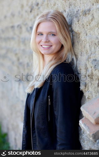 Pretty blonde single woman portrait outdoors with a wall of background