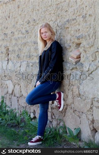 Pretty blonde single woman portrait outdoors with a wall of background