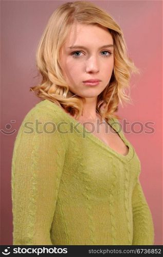 Pretty blonde teenager in a green knit sweater