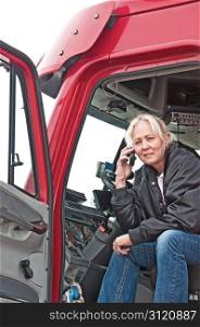 Pretty blonde truck driver getting directions to a delivery site on her cellphone.