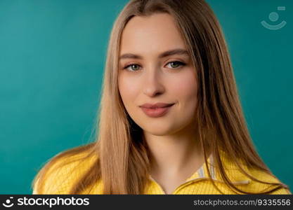 Pretty blonde woman, big lips on teal background. Smiling natural healthy girl lady with european appearance looking at camera. High quality photo. Pretty blonde woman, big lips on blue background. Smiling natural healthy girl
