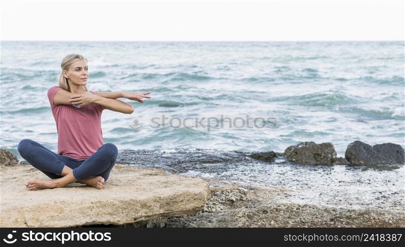 pretty blonde woman stretching beach