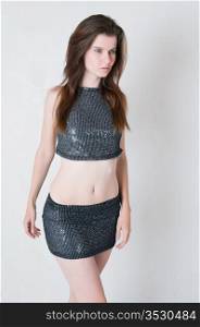 Pretty brown haired girl in a skimpy sequined blouse and skirt