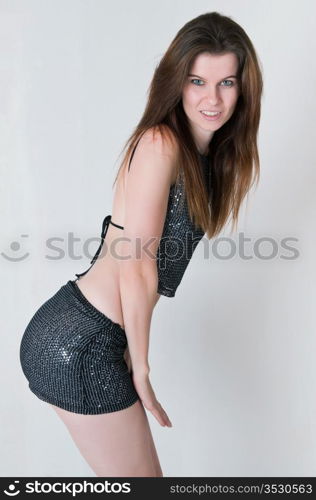 Pretty brown haired girl in a skimpy sequined blouse and skirt