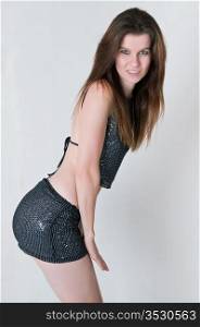 Pretty brown haired girl in a skimpy sequined blouse and skirt