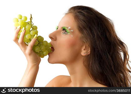 pretty brunette eating green grape and having green eyelashes