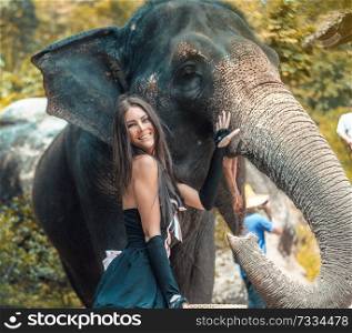 Pretty, brunette elephant trainer with her pet