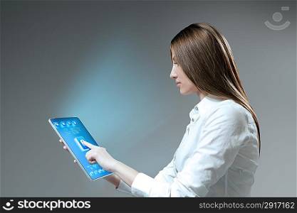 Pretty brunette girl touches pad device. Future collection.