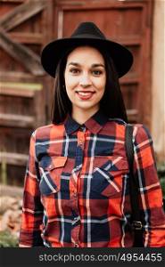 Pretty brunette girl with red plaid shirt and black hat