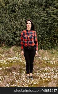 Pretty brunette girl with red plaid shirt in the park