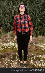 Pretty brunette girl with red plaid shirt in the park