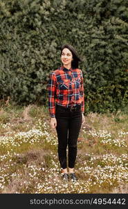 Pretty brunette girl with red plaid shirt in the park