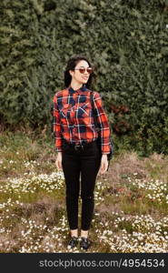 Pretty brunette girl with red plaid shirt in the park