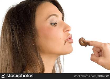 pretty brunette giving a kiss to some some chocolate cream on her finger