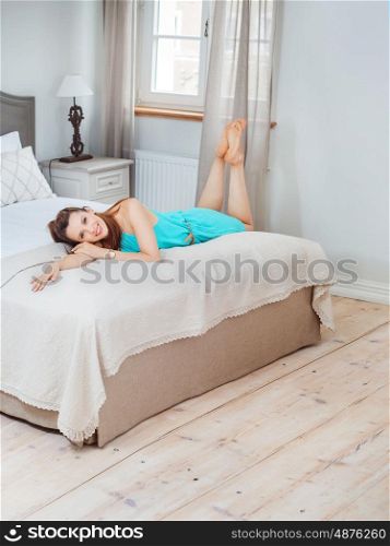 Pretty brunette lady lying on the wide bed