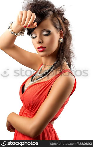pretty brunette with fashion hair style, red dress and some necklaces. Her body is turned in profile, she looks down and her right hand is on her front