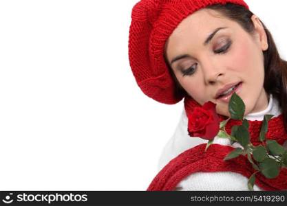 pretty brunette with red rose and assorted winter clothing