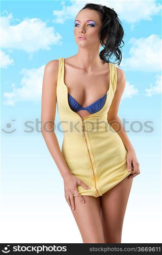 pretty brunette with unzipped short dress and blue bra, she looks at right and touches the edge on the dress