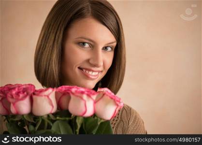 Pretty brunette woman holding bunch of roses