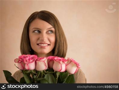 Pretty brunette woman holding bunch of roses