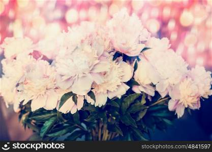 Pretty bunch of pink pale peonies with bokeh lighting, close up. Pastel floral background
