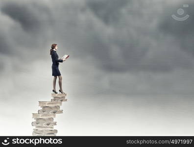 Pretty businesswoman in suit reading red book. Knowledge advantage