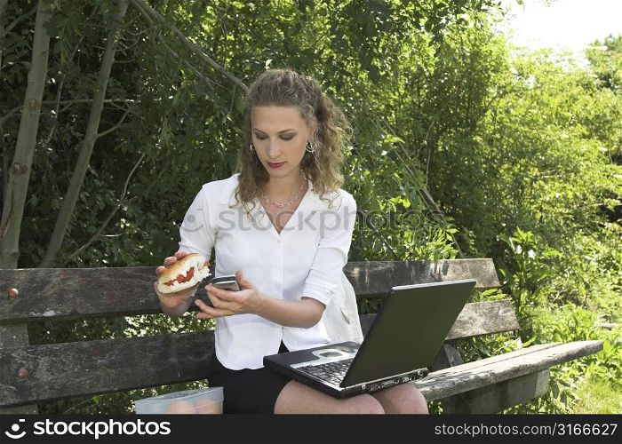 Pretty businesswoman in the park having a healthy lunch