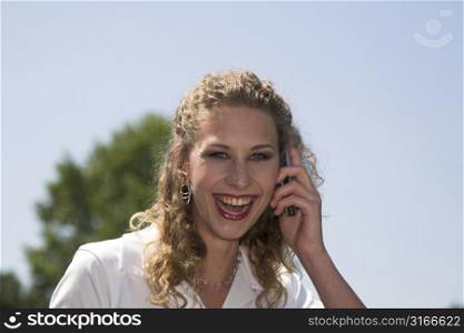 Pretty businesswoman laughing while on the phone outdoors