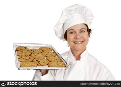 Pretty chef holding up a freshly baked batch of toll house cookies. Isolated on white.