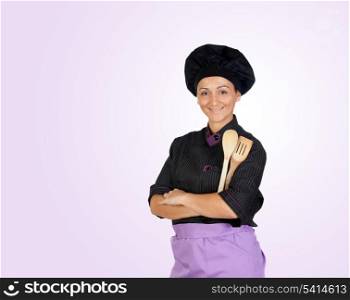 Pretty cook girl with wooden cookware isolated on purple background