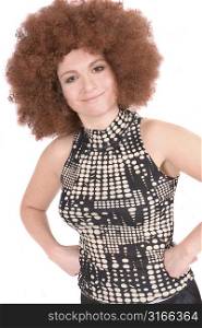 Pretty curly woman with red afro wig with her hands in her side