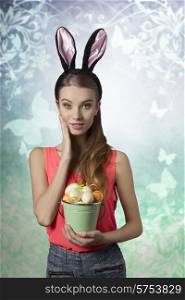 Pretty, easter girl with rabbit, fluffy ears and bucket of easter eggs. She wears to and jeans shorts. She has got nice make up.