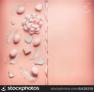 Pretty Easter pastel pink composing layout with eggs,ribbon,bow, birds and feather on table background, top view, flat lay