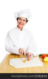 Pretty female chef chopping up vegetables in her kitchen. Isolated on white.