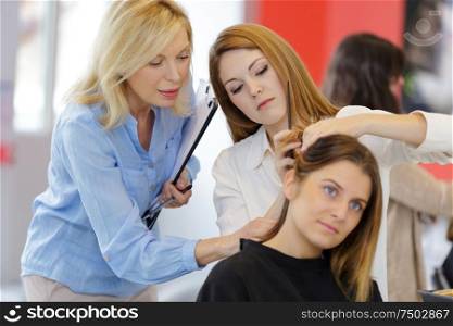 pretty female hairdresser training on an apprentice head